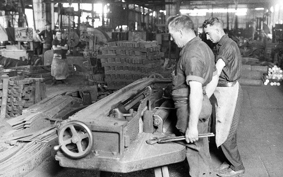 The only protective clothing worn by these workers in the Spring Shop in the 1920s was an apron tied at the waist. 